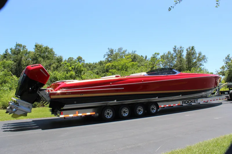 Lady Lisa Yacht Photos Pics 2023 Nor-Tech 55 Flyer boat on trailer, vibrant red, parked on road.
