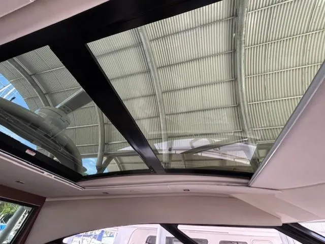 Va Bene Yacht Photos Pics Interior view of 2015 Sea Ray 470 Sundancer's sunroof under a covered dock.