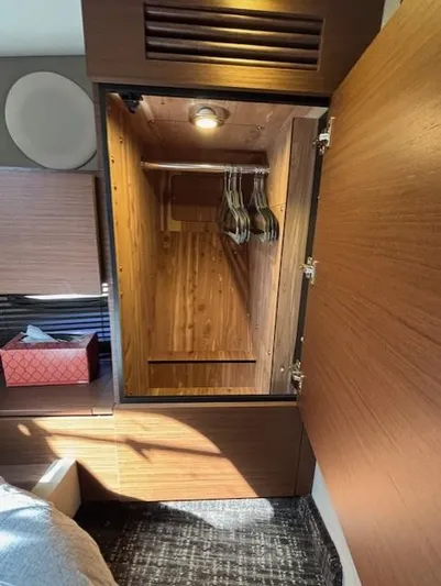Va Bene Yacht Photos Pics 2015 Sea Ray 470 Sundancer cabin closet with wooden interior and hangers.