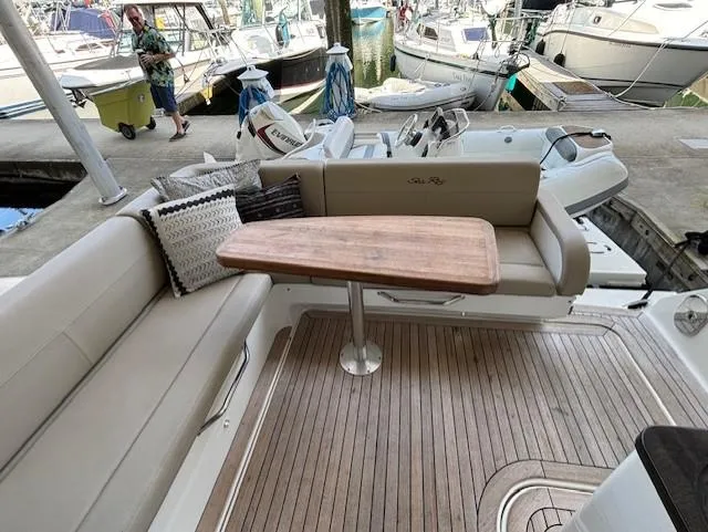 Va Bene Yacht Photos Pics 2015 Sea Ray 470 Sundancer yacht interior with seating and wooden table at marina.