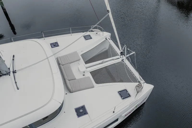 Yacht Photos Pics Aerial view of 2022 Lagoon 46 catamaran with netted deck and cushioned seating.