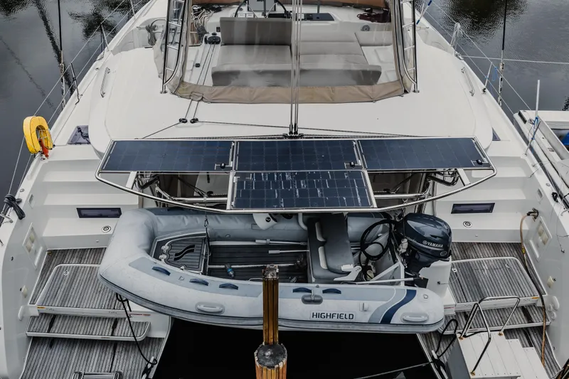  Yacht Photos Pics 2022 Lagoon 46 catamaran with solar panels and inflatable dinghy on deck.