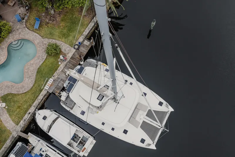  Yacht Photos Pics Aerial view of 2022 Lagoon 46 catamaran docked near a pool and garden.
