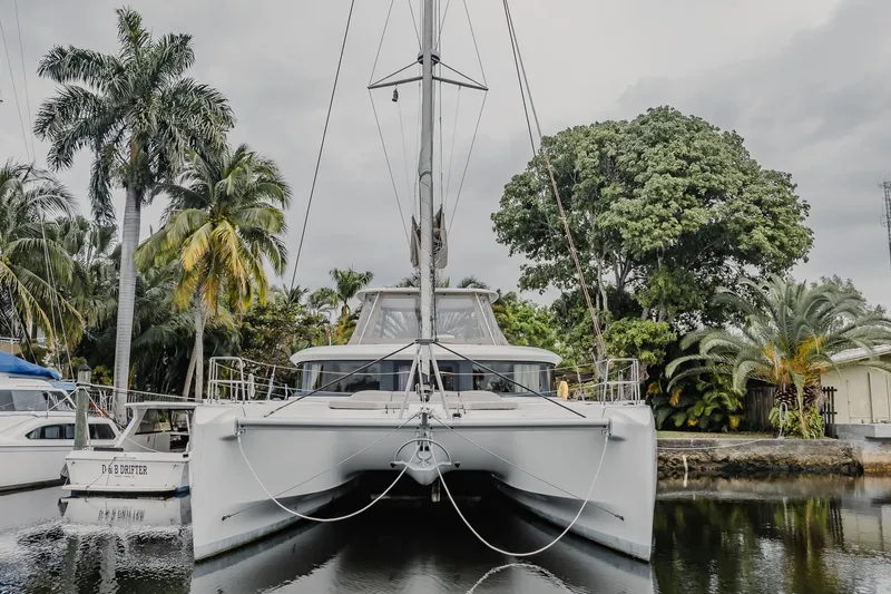  Yacht Photos Pics 2022 Lagoon 46 catamaran docked among tropical palm trees.