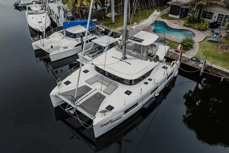  Yacht Photos Pics 2022 Lagoon 46 catamaran docked by a poolside, showcasing modern design and spacious deck.