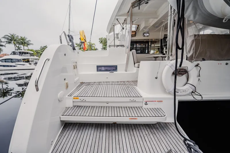  Yacht Photos Pics 2022 Lagoon 46 yacht stern view with steps and lifebuoy in marina setting.
