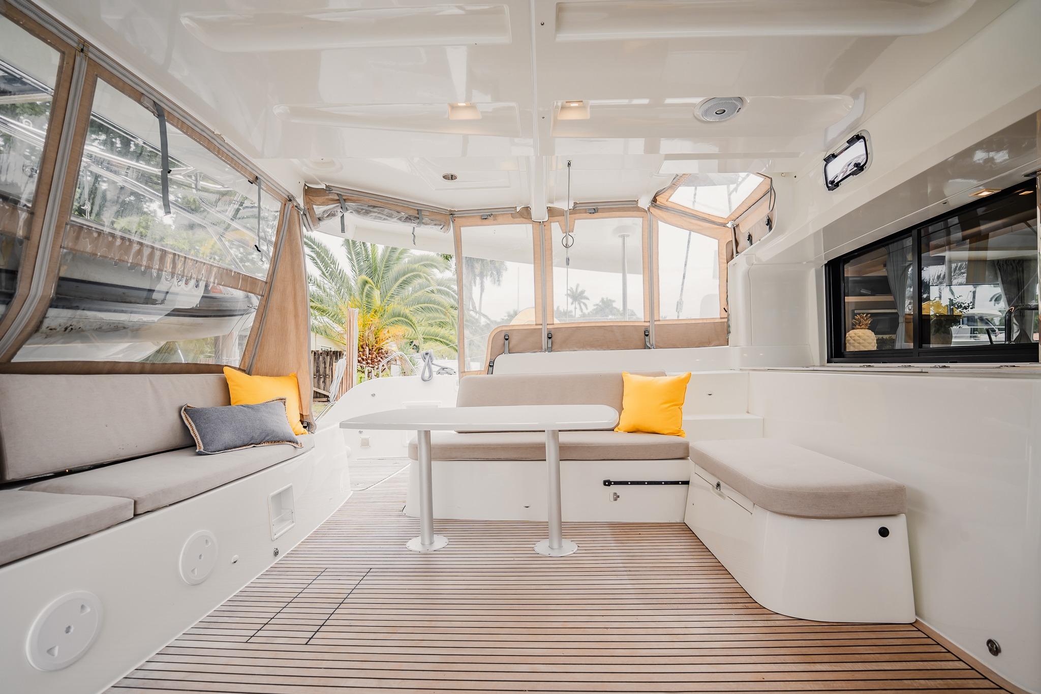 Spacious interior of 2022 Lagoon 46 catamaran with modern seating and wooden flooring.