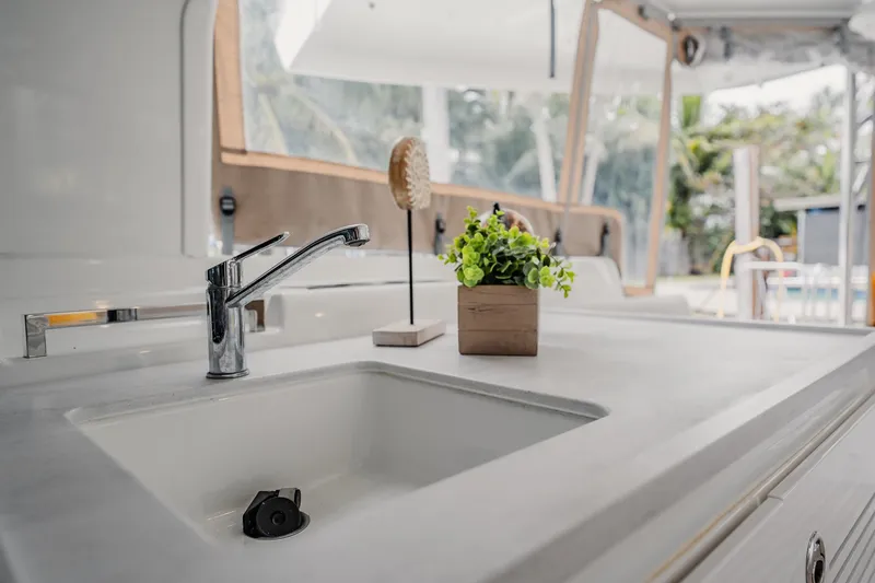  Yacht Photos Pics Modern kitchen sink on Lagoon 46 yacht, 2022 model, with plant decor.
