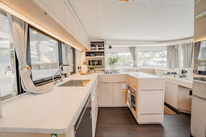  Yacht Photos Pics Modern kitchen interior of 2022 Lagoon 46 yacht with sleek countertops and ample natural light.