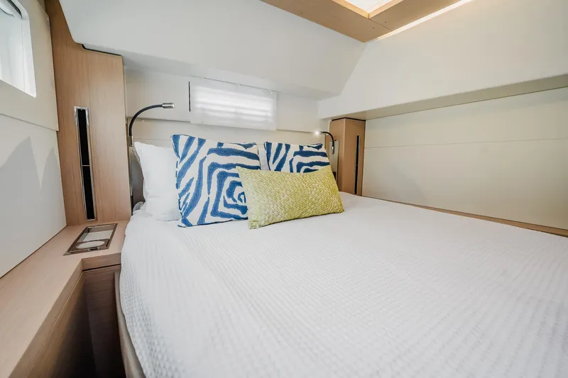  Yacht Photos Pics Luxurious bedroom interior of 2022 Lagoon 46 yacht with stylish bedding.