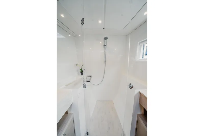  Yacht Photos Pics Modern shower area in 2022 Lagoon 46 yacht, featuring sleek design and bright lighting.