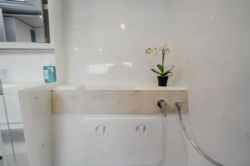  Yacht Photos Pics Modern bathroom interior of 2022 Lagoon 46 yacht with sleek design and floral decor.