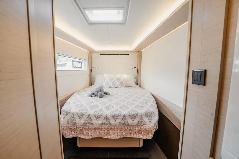  Yacht Photos Pics Luxurious bedroom interior of 2022 Lagoon 46 yacht with elegant bedding and soft lighting.