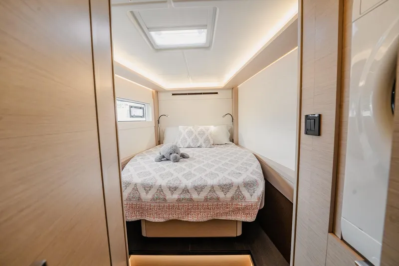  Yacht Photos Pics Luxurious bedroom interior of 2022 Lagoon 46 yacht with cozy bed and modern lighting.