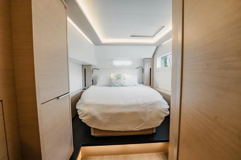  Yacht Photos Pics Luxurious bedroom interior of 2022 Lagoon 46 yacht with modern design and cozy bedding.