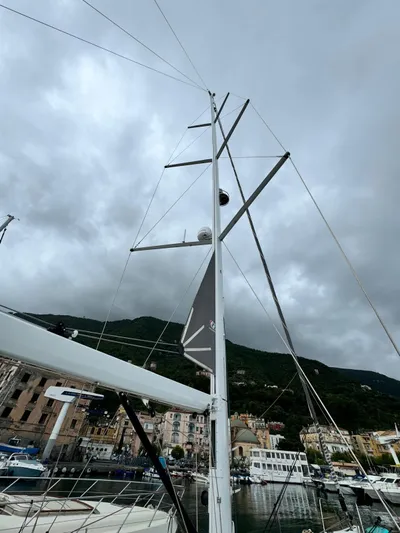 Blue Art Yacht Photos Pics 2023 Jeanneau 65 sailboat mast against cloudy sky in marina setting.