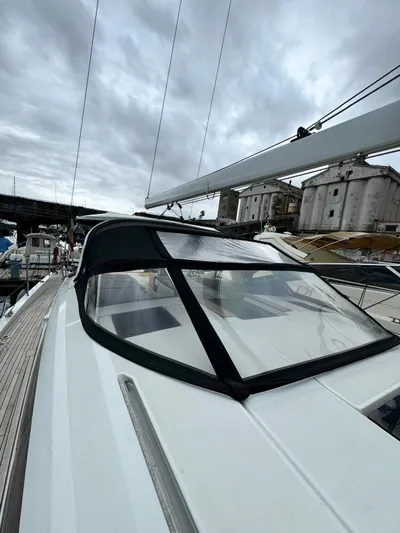 Blue Art Yacht Photos Pics 2023 Jeanneau 65 yacht with sleek design, docked under cloudy skies.