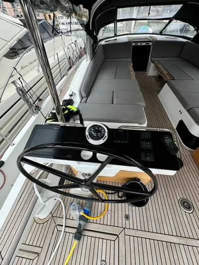 Blue Art Yacht Photos Pics 2023 Jeanneau 65 yacht cockpit with steering wheel and cushioned seating.