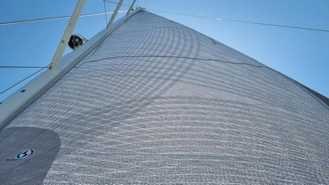 Blue Art Yacht Photos Pics Sail of 2023 Jeanneau 65 yacht against clear blue sky.