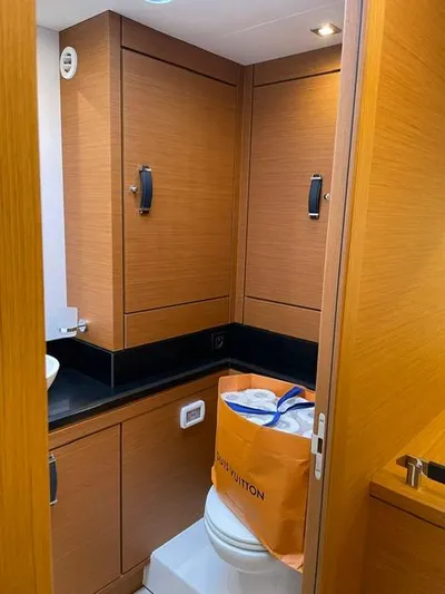 Blue Art Yacht Photos Pics Bathroom interior of 2023 Jeanneau 65 yacht with wooden cabinets and modern fixtures.
