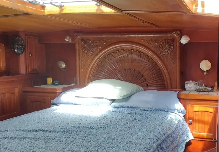 Pacific High Yacht Photos Pics Luxurious wooden cabin interior with ornate headboard, Custom 62 model, 1983.