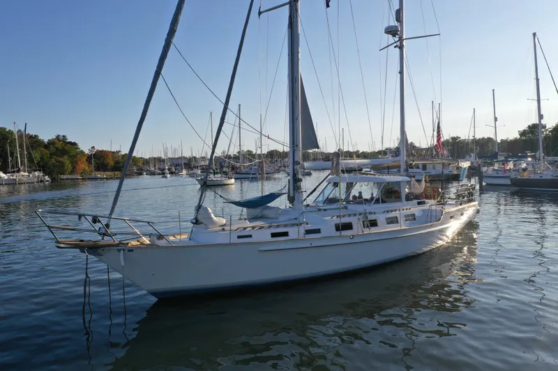 Pacific High Yacht Photos Pics Sailboat on calm water, Custom 62 model, 1983, docked in a marina.