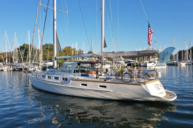 Pacific High Yacht Photos Pics Sailboat in marina, Custom 62 model, 1983, with American flag, clear blue sky.