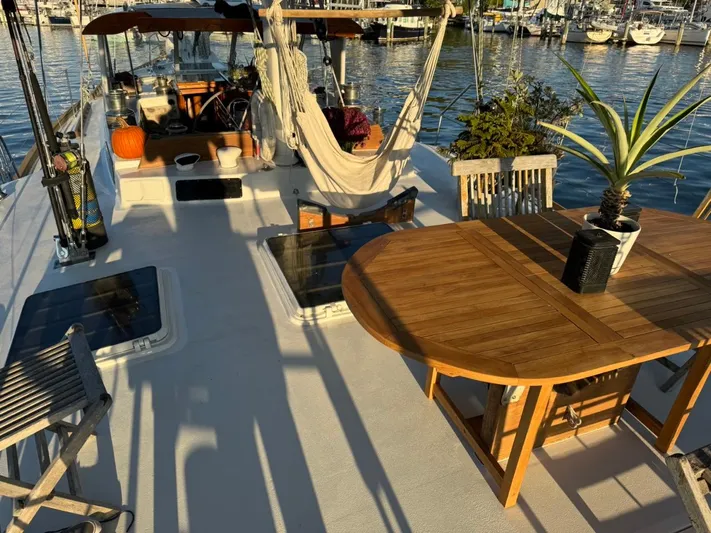 Pacific High Yacht Photos Pics Deck of a 1983 Custom 62 boat with hammock, table, and plants.