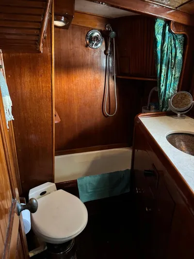Pacific High Yacht Photos Pics Vintage 1983 Custom 62 boat bathroom with wood paneling and compact fixtures.