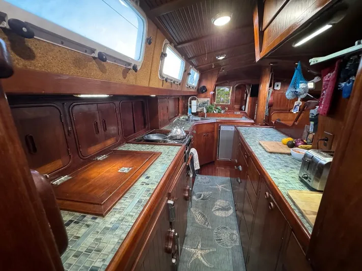 Pacific High Yacht Photos Pics 1983 Custom 62 yacht interior with wooden cabinetry and tiled countertops.