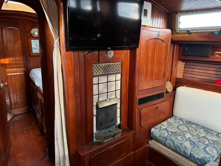 Pacific High Yacht Photos Pics Interior of a 1983 Custom 62 boat with wood paneling and cozy seating area.
