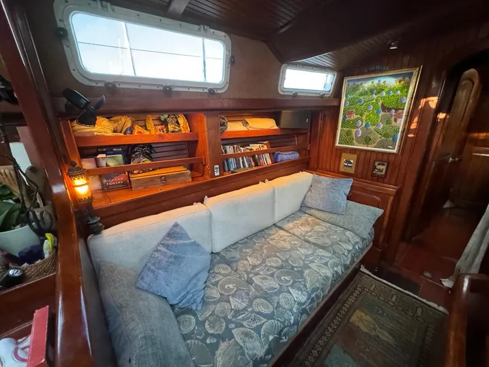 Pacific High Yacht Photos Pics Cozy 1983 Custom 62 yacht interior with cushioned seating, wooden shelves, and nautical decor.