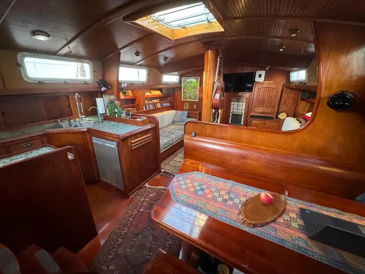 Pacific High Yacht Photos Pics Luxurious 1983 Custom 62 yacht interior with wood finish, kitchen, and seating area.