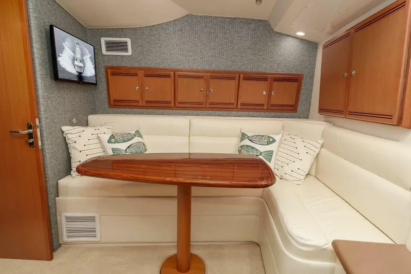 Show Time Yacht Photos Pics 2008 Cabo Yachts 38 EXPRESS interior with white seating, wooden table, and wall cabinets.
