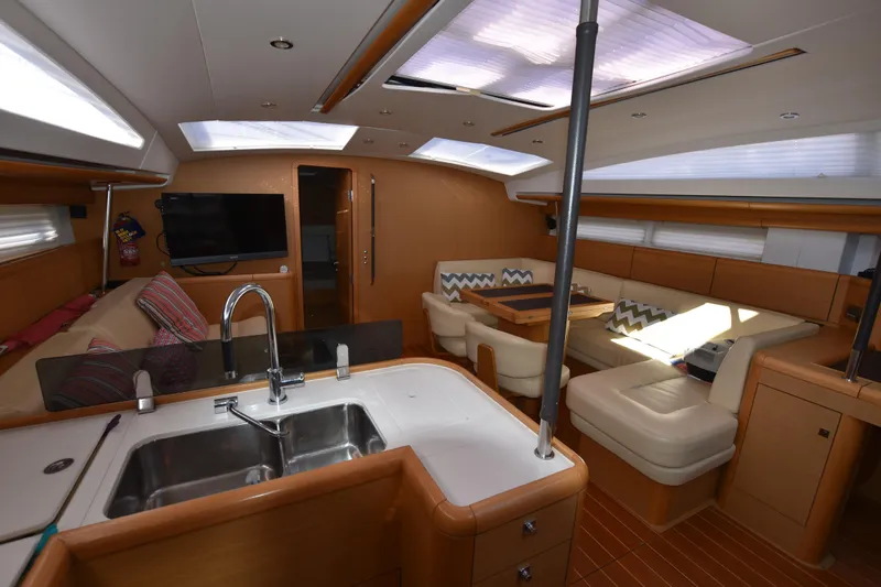Lady Evelina Yacht Photos Pics Luxurious interior of 2010 Jeanneau 57 yacht with modern kitchen and cozy seating area.