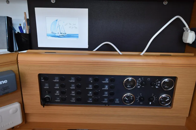 Lady Evelina Yacht Photos Pics Control panel of a 2010 Jeanneau 57 yacht with nautical artwork above.
