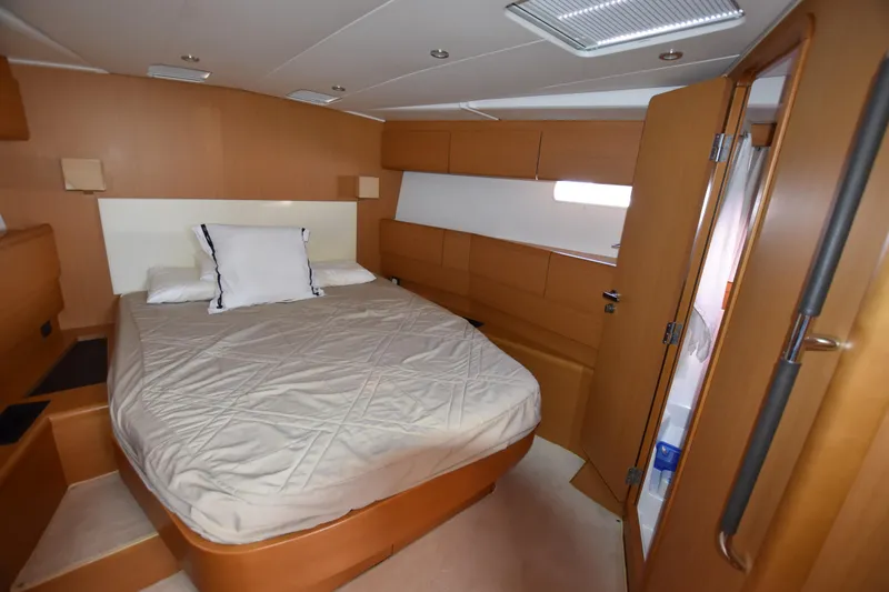 Lady Evelina Yacht Photos Pics Luxurious cabin interior of 2010 Jeanneau 57 yacht with cozy bed and wooden finish.