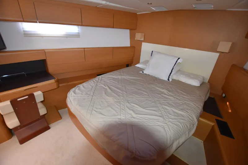 Lady Evelina Yacht Photos Pics Luxurious cabin interior of 2010 Jeanneau 57 yacht with cozy bed and wooden furnishings.
