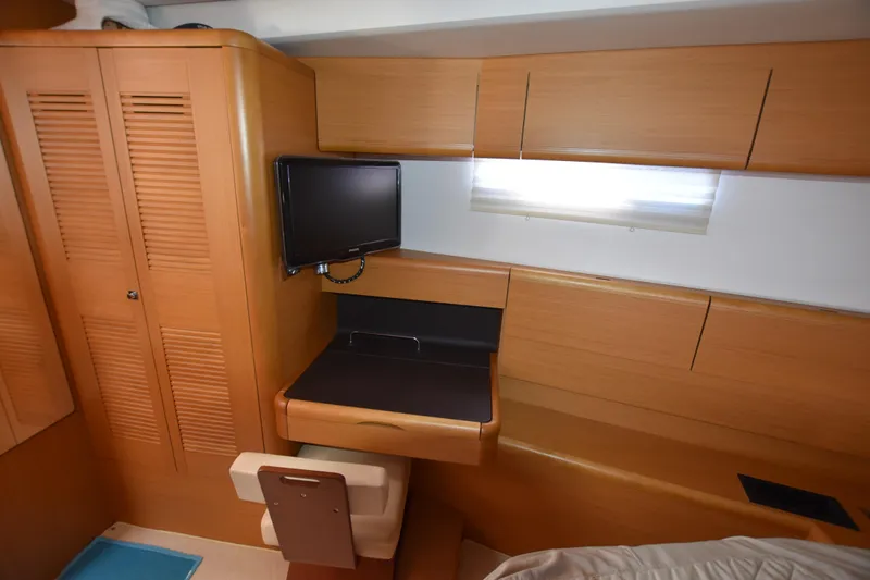 Lady Evelina Yacht Photos Pics Interior of 2010 Jeanneau 57 yacht with wooden cabinetry and small TV.