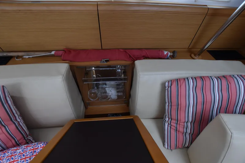 Lady Evelina Yacht Photos Pics Interior of 2010 Jeanneau 57 yacht with striped cushions and glass storage.