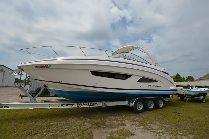 Mountaineer Mayhem Yacht Photos Pics 2018 Regal 33XO boat on trailer, side view, cloudy sky background.