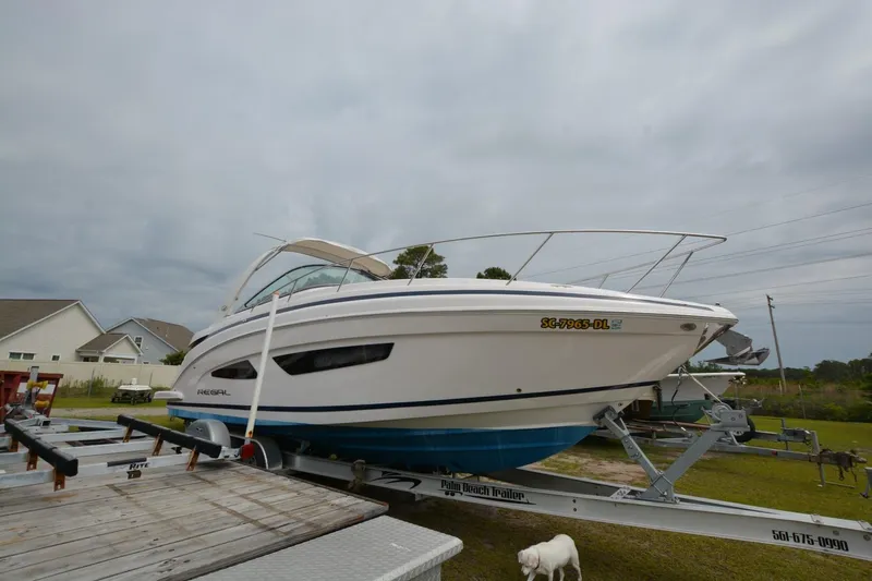 Mountaineer Mayhem Yacht Photos Pics 2018 Regal 33XO boat on trailer, parked outdoors under cloudy sky.