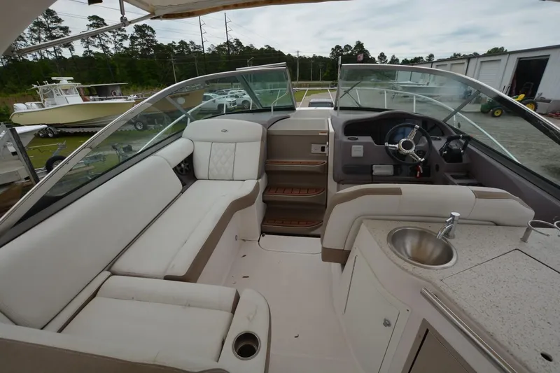 Mountaineer Mayhem Yacht Photos Pics 2018 Regal 33XO boat interior with seating, steering wheel, and sink.