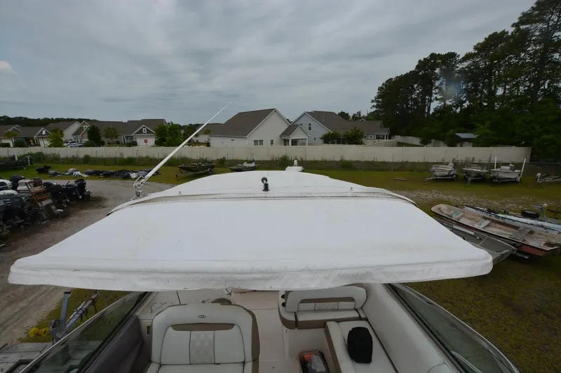 Mountaineer Mayhem Yacht Photos Pics 2018 Regal 33XO boat with canopy, parked in a residential area.