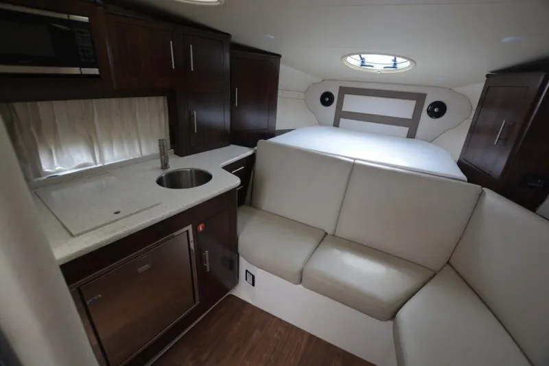 Mountaineer Mayhem Yacht Photos Pics 2018 Regal 33XO cabin interior with kitchenette, seating, and bed.