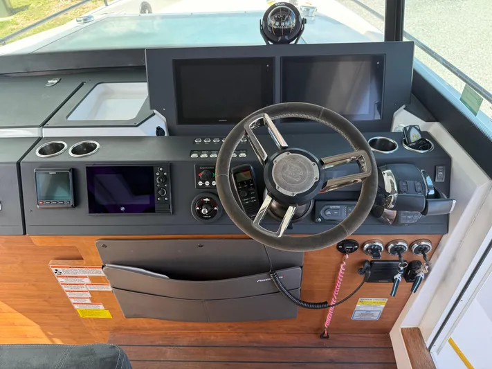 Meraki Yacht Photos Pics 2019 Axopar AX37XC boat dashboard with steering wheel and navigation controls.