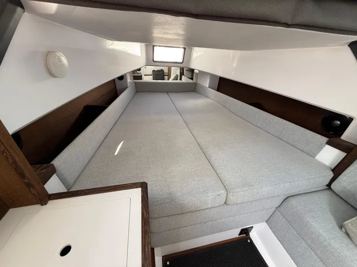Meraki Yacht Photos Pics 2019 Axopar AX37XC cabin interior with gray cushions and wooden accents.