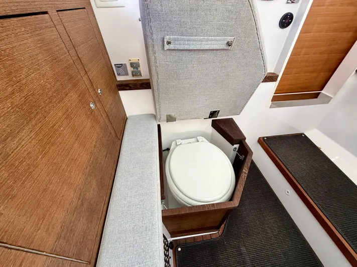 Meraki Yacht Photos Pics 2019 Axopar AX37XC boat interior with compact toilet and wooden cabinetry.