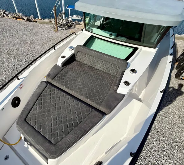 Meraki Yacht Photos Pics 2019 Axopar AX37XC boat with cushioned seating, docked by the water.