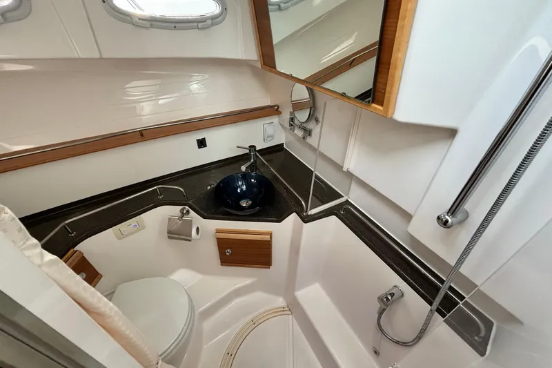 Yacht Photos Pics 2023 Cutwater C-32 Coupe bathroom with modern sink, shower, and wooden accents.